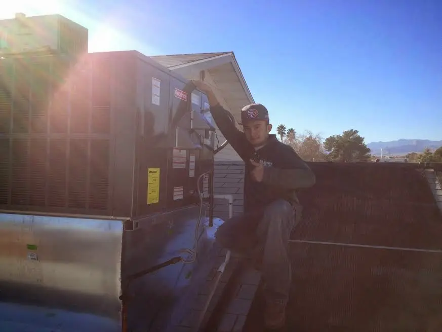 HVAC technician performing Boiler Repair on a rooftop unit in Miles City