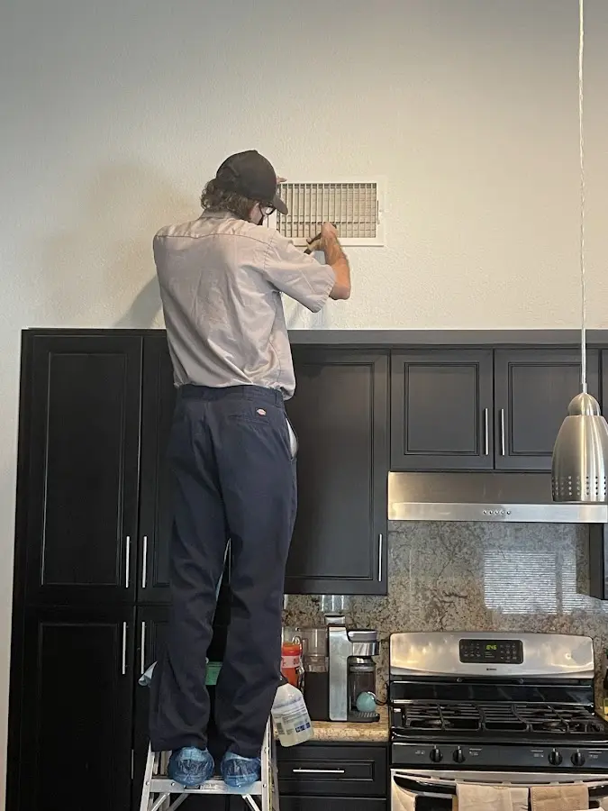 Technician inspecting an air vent during HVAC service in Miles City